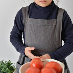 Kids pinafore apron in charcoal, linen and cotton fabric, tie back and roomy pockets in front